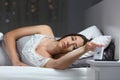 Woman waking up in the night turning off alarm clock Royalty Free Stock Photo