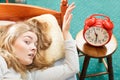 Woman waking up turning off alarm clock in morning Royalty Free Stock Photo