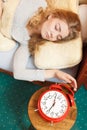 Woman waking up turning off alarm clock in morning Royalty Free Stock Photo