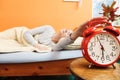 Woman waking up turning off alarm clock in morning Royalty Free Stock Photo