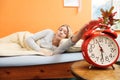 Woman waking up turning off alarm clock in morning Royalty Free Stock Photo