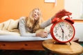 Woman waking up turning off alarm clock in morning Royalty Free Stock Photo