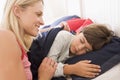 Woman waking young boy in bed smiling Royalty Free Stock Photo