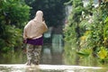A Woman walk in high waters. Heavy rains caused floods in many areas around Bekasi