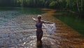 Woman walk on water on pier in sunglasses and a boho silk shawl. Girl rest on flood wood underwater dock. The pavement Royalty Free Stock Photo