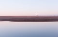 Woman walking on Aberdeen beach reflected in the Don river Royalty Free Stock Photo
