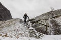 Woman walking alone, climbing a mountain in snowy weather. Royalty Free Stock Photo