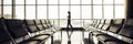 Woman walking alone in an empty airport waiting gate in departures area. Concept of people travel and fly on airplane Royalty Free Stock Photo