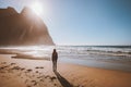 Woman walking alone on Kvalvika beach in Norway enjoying ocean view