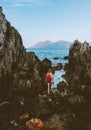 Woman walking alone looking at sea rocks coast in Norway enjoying ocean view