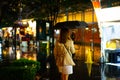 A woman is walking alone at the night street in the rainy season Royalty Free Stock Photo