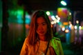 A woman is walking alone at the night street in the rainy season Royalty Free Stock Photo