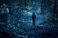 Woman walking alone on path in mystic dark forest. Lonely adult girl in strange creepy park at night in autumn