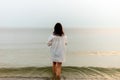 Woman walking along beach and sea sunset background.Loneliness and sadness concept.Empty place for text.Back view Royalty Free Stock Photo