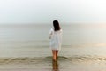 Woman walking along beach and sea sunset background.Loneliness and sadness concept.Empty place for text.Back view Royalty Free Stock Photo