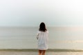 Woman walking along beach and sea sunset background.Loneliness and sadness concept.Empty place for text.Back view Royalty Free Stock Photo