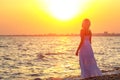 Woman walking along the beach at sunset or sunrise hours of rest Royalty Free Stock Photo