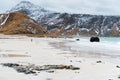 Woman walking along an empty ocean beach Kvalvika and looking at the mountains. Fjord in Norway. Scenic view. Travel, adventure. Royalty Free Stock Photo