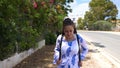 Woman walking along road in tropics. Beautiful woman traveler walking along the road Royalty Free Stock Photo