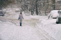 Woman walking along a snowbound Moscow street in February