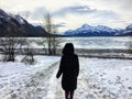 A woman walking along an unknown path towards a frozen lake in a beautiful winter landscape on Abraham Lake, Alberta, Canada. Royalty Free Stock Photo