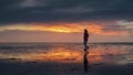 Woman walking along the Wadden Sea in Buesum during dramatic sunset Royalty Free Stock Photo