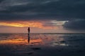 Woman walking along the Wadden Sea in Buesum during dramatic sunset Royalty Free Stock Photo