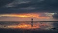 Woman walking along the Wadden Sea in Buesum during dramatic sunset Royalty Free Stock Photo