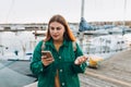 Woman walking along the waterfront, seaside. High quality photo. Negative people emotion. Upset young 30s woman is using