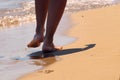 Woman walking barefoot on the sand leaving footprints on the golden beach.Female legs walk by the sea.Vacation, summer vacation or Royalty Free Stock Photo