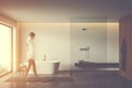 Woman walking in bathroom with tub and shower Royalty Free Stock Photo