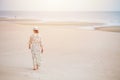 Woman walking on the beach alone lonely with space for text