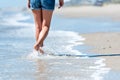 Woman walking on the beach next to ocean