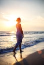 Woman walking on the beach in the surf at sunset Royalty Free Stock Photo