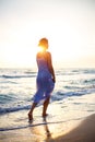 Woman walking on the beach in the surf at sunset Royalty Free Stock Photo