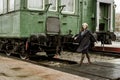 Woman walking behind green vintage trains