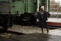 Woman walking behind green vintage trains