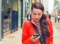 Woman walking on a city street and using her mobile phone Royalty Free Stock Photo