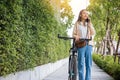 woman walking in countryside outdoor with her bicycle she using mobile phone talking with friend Royalty Free Stock Photo