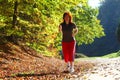 Woman walking cross country trail in autumn forest Royalty Free Stock Photo