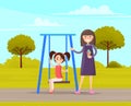 Woman walking with daughter girl swinging on slide swing at playing field outdoor family activities Royalty Free Stock Photo