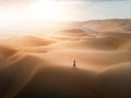 Woman walking on the desert sand dunes aerial view Royalty Free Stock Photo
