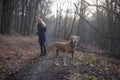 Woman walking dog in forest Royalty Free Stock Photo
