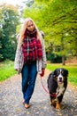 Woman walking the dog on leash in park Royalty Free Stock Photo