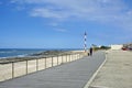 Woman walking with a dog on promenade along the Apulia, Portugal