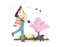 Woman walking with dog wearing cute coat in spring park over blooming trees and flowers