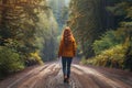 Woman Walking Down Dirt Road in Woods Royalty Free Stock Photo