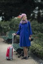 Woman walking down the street with a red suitcase in her hand Royalty Free Stock Photo