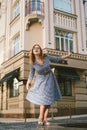 Woman walking in dress in old city. Fashion Style Photo Of A Young Girl. happy stylish woman at old european city street Royalty Free Stock Photo