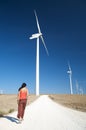 Woman walking between energy mills Royalty Free Stock Photo